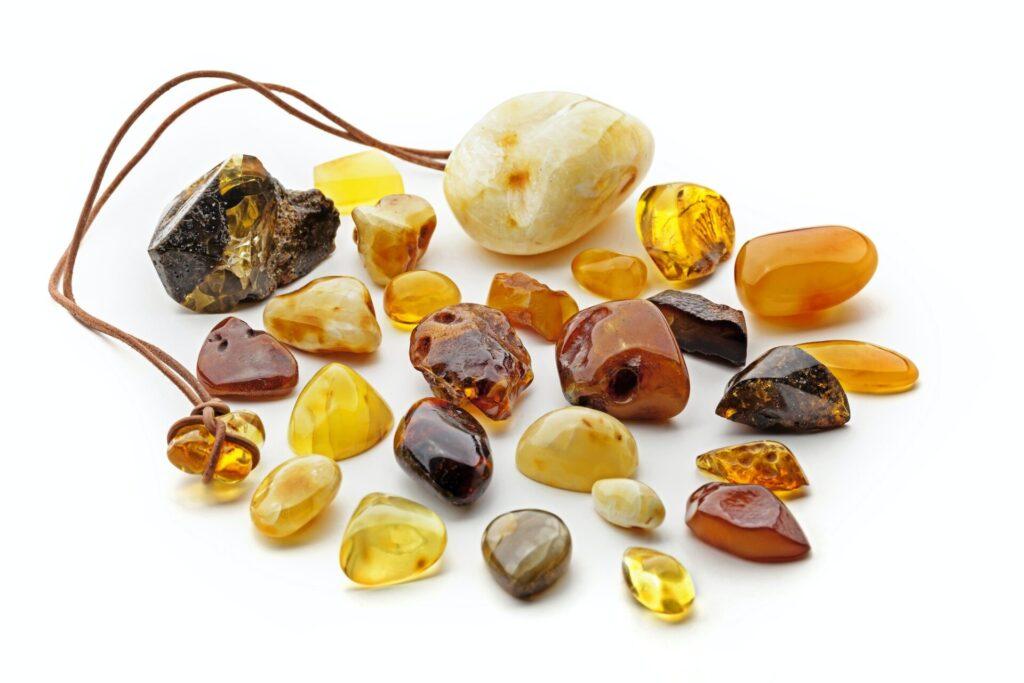 Natural amber. Many pieces of different colors of natural amber on white background